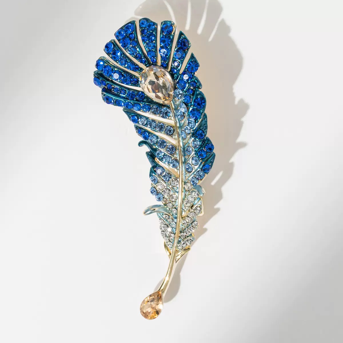 Gradually changing blue feather brooch